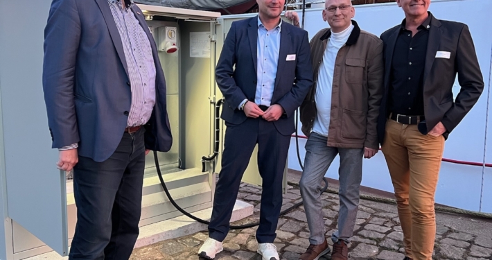 IMG_8795 Vier Männer stehen vor einem offenen Stromkasten vor einem historischen Raddampfer.